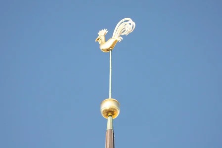 Golden Weather Vane Against Blue Sky