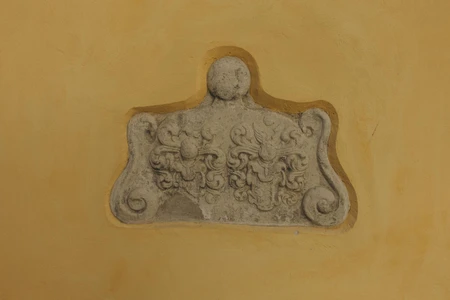 Ornate Stone Plaque on Yellow Wall