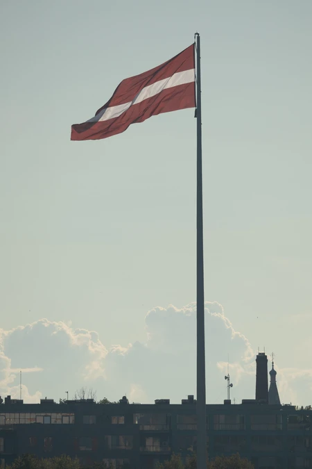 Latvian Flag Over City Skyline