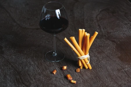 Wine and Breadsticks on Wooden Surface