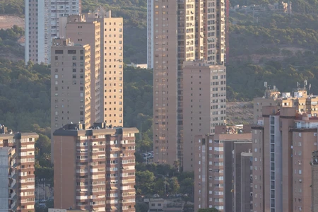Urban Skyscrapers Against Hill Landscape