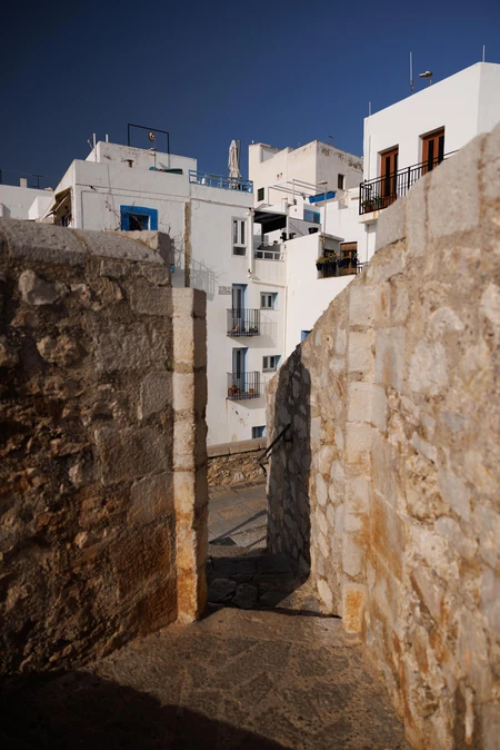 Stone Passageway with White Buildings