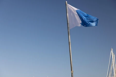 Blue and White Flag Against Clear Sky