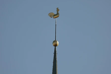 Golden Weather Vane Against Blue Sky