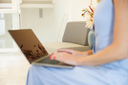 Woman Using Laptop in Minimalist Setting