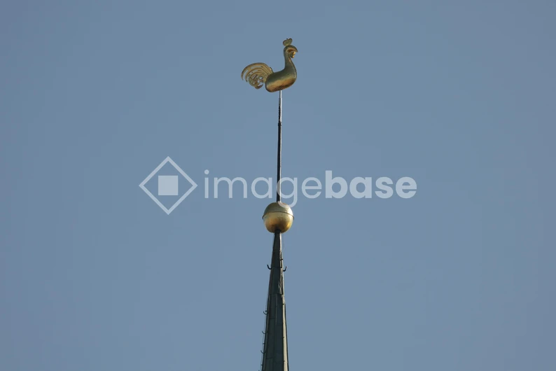 Golden Weather Vane Against Blue Sky