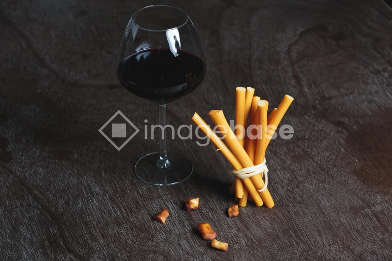 Wine and Breadsticks on Wooden Surface