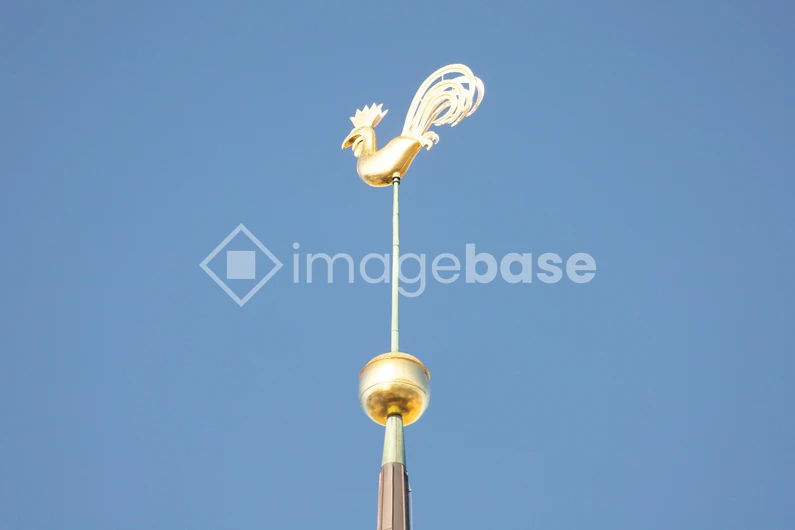 Golden Weather Vane Against Blue Sky