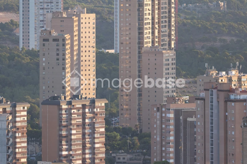 Urban Skyscrapers Against Hill Landscape