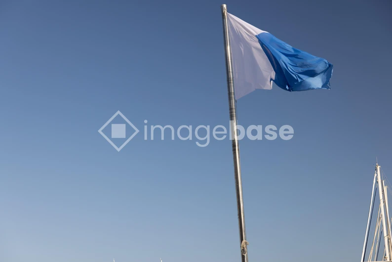 Blue and White Flag Against Clear Sky