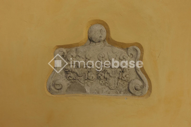 Ornate Stone Plaque on Yellow Wall
